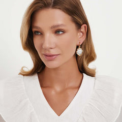 Earrings Coiné worn by a model, showcasing gold-plated brass with textured antique coin design.
