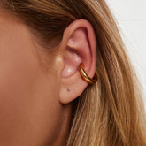Earcuff Renude - polished gold cuff earring on ear, showcasing sleek design and minimalist elegance.