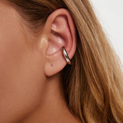 Earcuff Renude worn on an ear, showcasing its sleek gold-plated design and minimalist style.