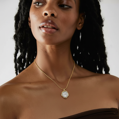 Model showcasing Necklace Coiné, a gold-plated necklace with an intricate coin pendant.