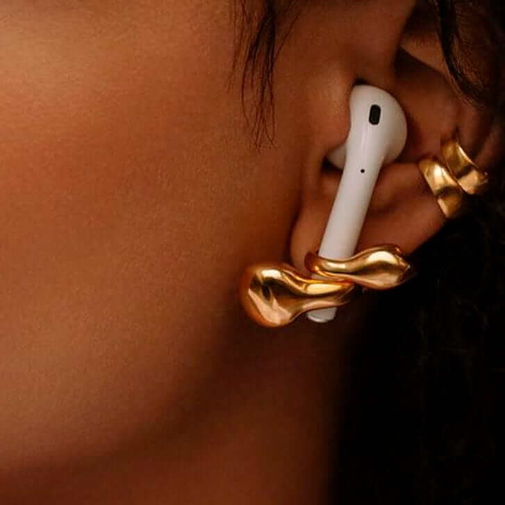 Earrings Looppods stylishly holding AirPods in a gold brass holder, showcasing effortless elegance and function.