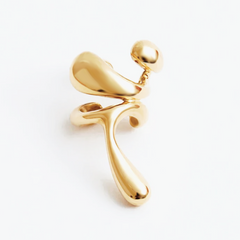 Earcuff Lilt in gold-plated brass, featuring an organic silhouette and delicate curves for a striking ear accessory.