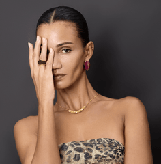 Model showcasing Earrings Arc, modern brass design with 18k gold plating and faux leather accents.