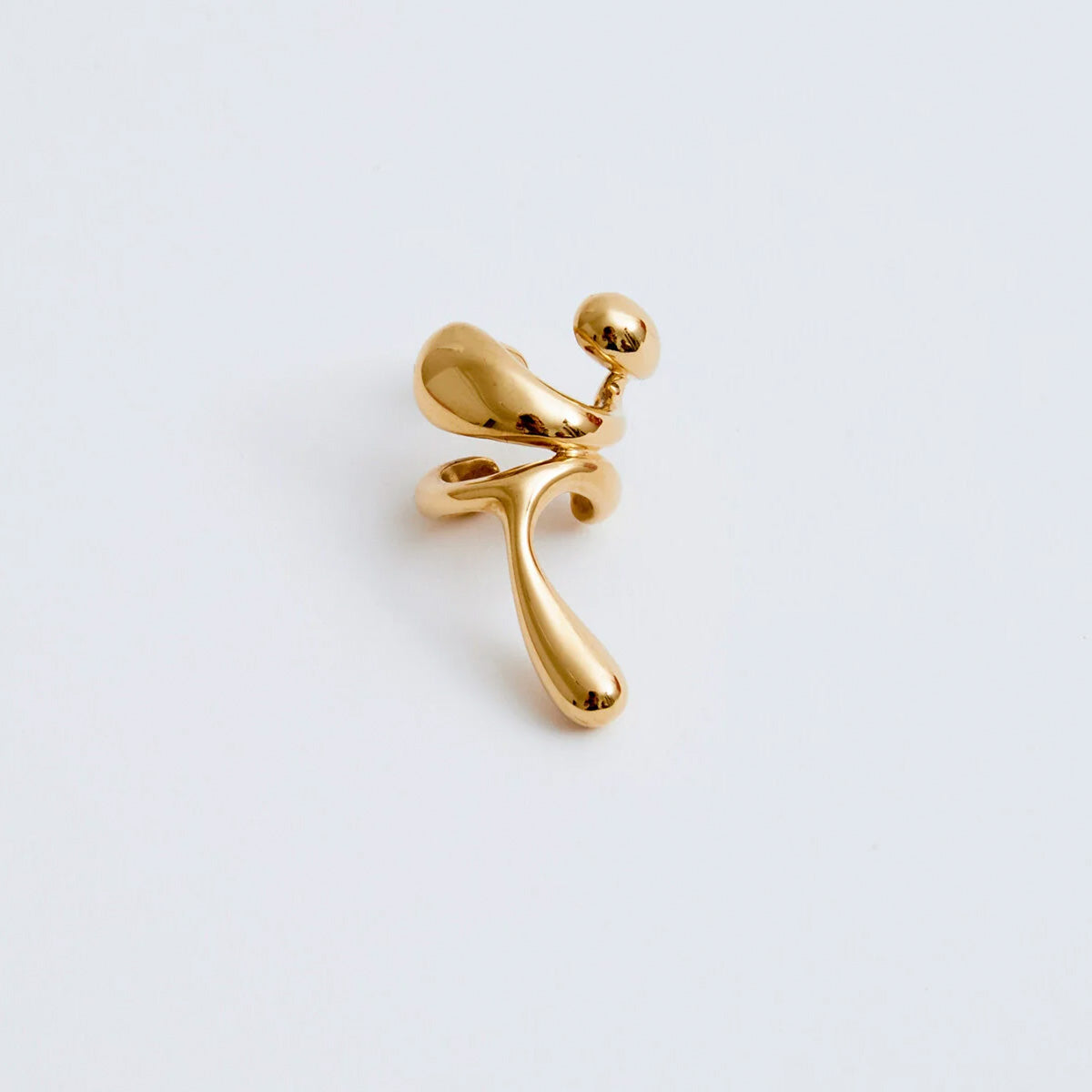 Earcuff Lilt in gold-plated brass, showcasing organic curves and sculptural design, adding daring elegance.