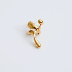 Earcuff Lilt in gold-plated brass, showcasing organic curves and sculptural design, adding daring elegance.