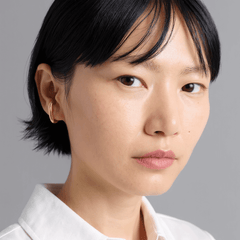 Earcuff Clip worn by a model, showcasing minimalist design and polished curves in brass, gold-plated material.