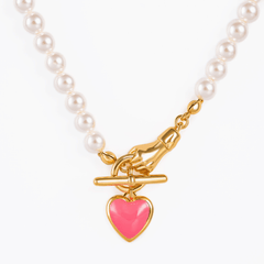 Necklace Amour featuring pearls, gold-plated clasp, and vibrant pink heart pendant.