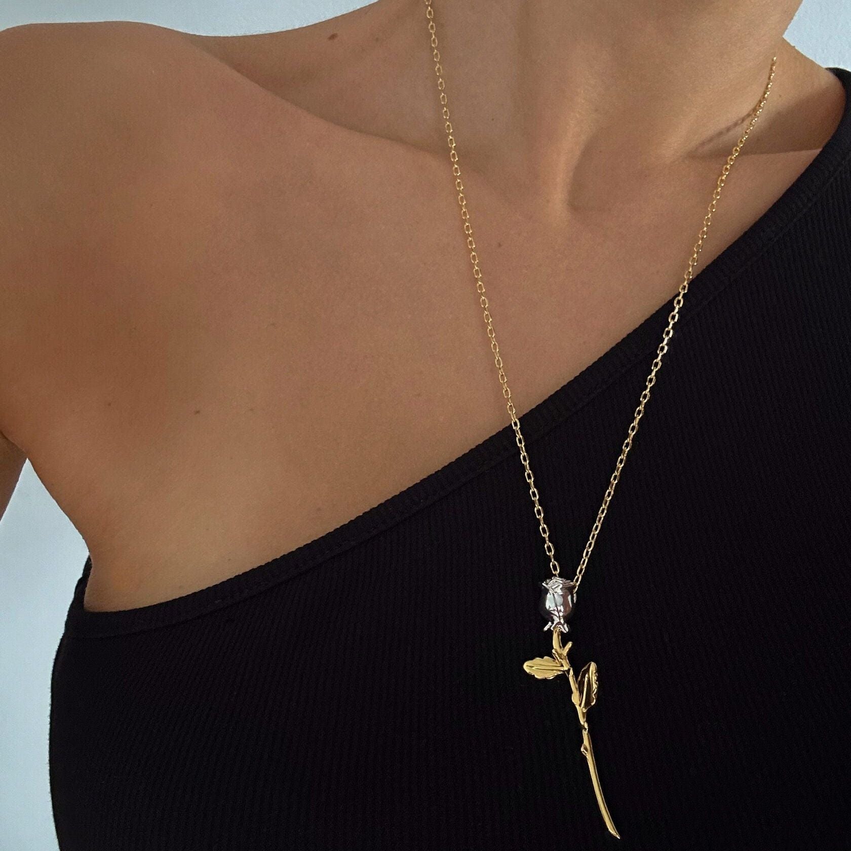 Necklace Bloom featuring a delicate rose pendant on a gold chain, showcasing timeless beauty and elegance.