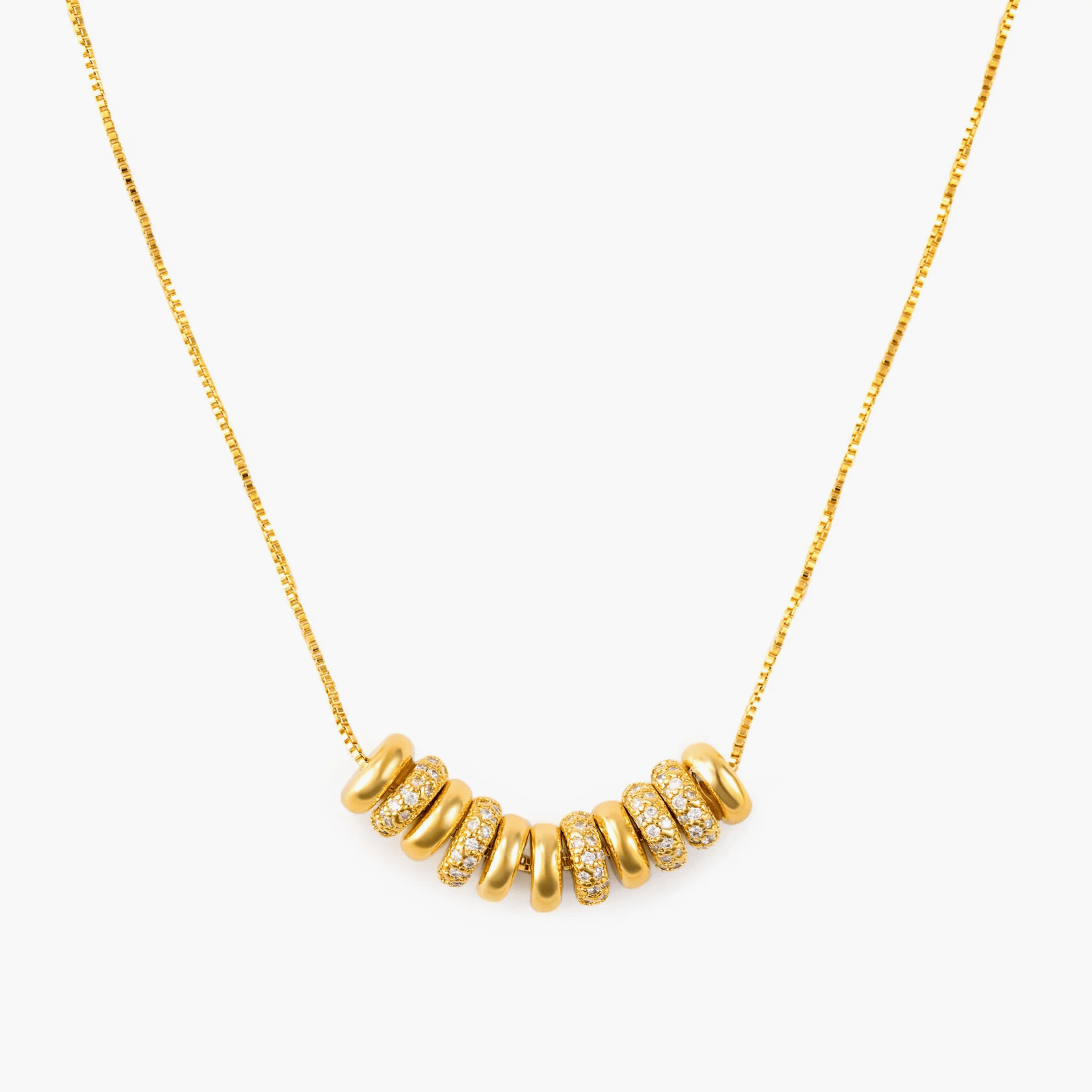 Necklace Cascade featuring gold-plated brass and zircon inlay, showcasing radiant rings in a minimalistic design.