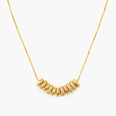 Necklace Cascade featuring gold-plated brass and zircon inlay, showcasing radiant rings in a minimalistic design.