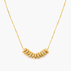 Necklace Cascade featuring gold-plated brass and zircon inlay, showcasing radiant rings in a minimalistic design.