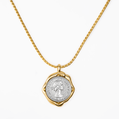 Necklace Coiné featuring a gold-plated pendant with an intricate coin design and a molten-inspired frame.