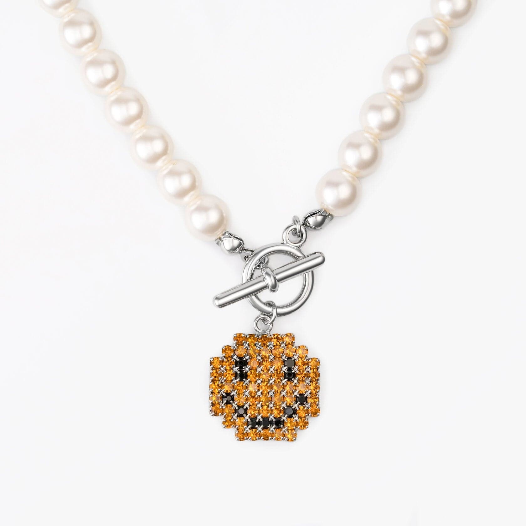 Necklace Smile featuring brass, pearl, platinum plating, and a playful zircon inlay charm.