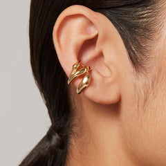 Close-up of Earcuff Flow showcasing its sculptural gold design wrapped around the ear cartilage.