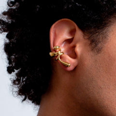 Earcuff Lilt worn on ear, showcasing its delicate, gold-plated design and organic curves.