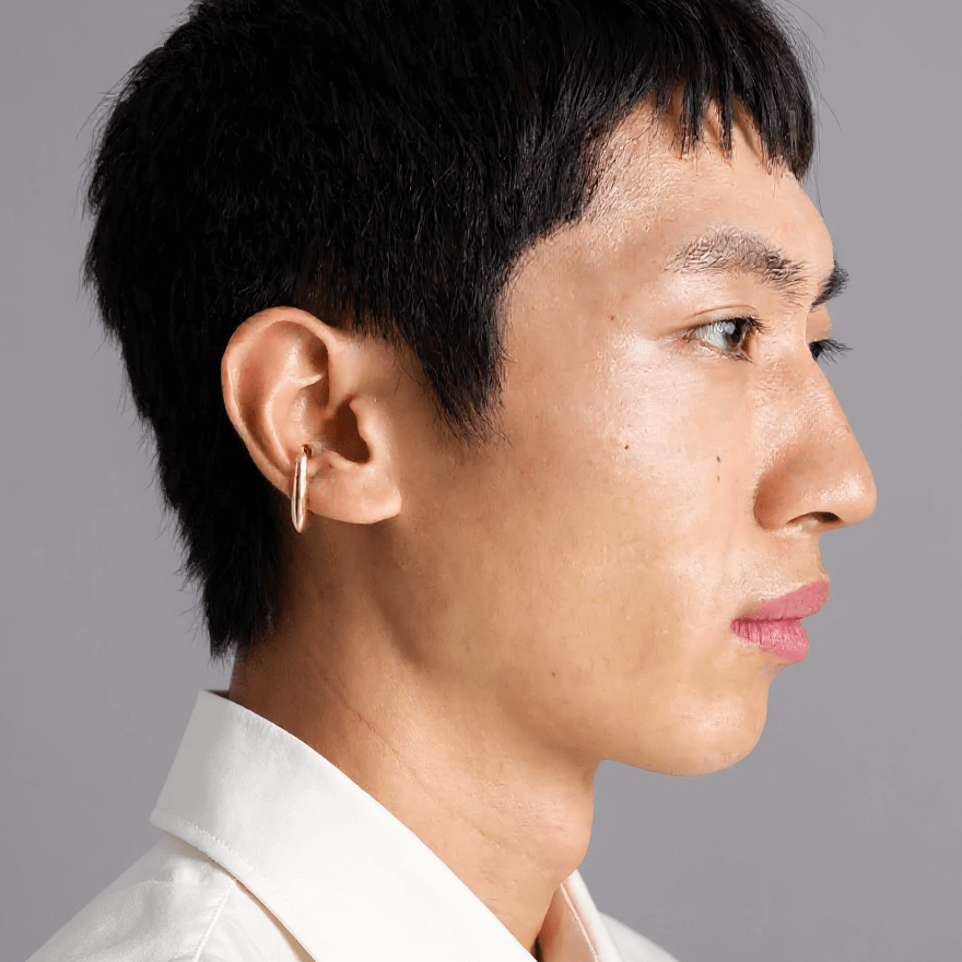 Profile view of a person wearing a stylish Earcuff Clip made of brass with a gold finish.