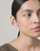 Earcuff Flow worn by a model, showcasing the sculptural gold design and bold ear styling.